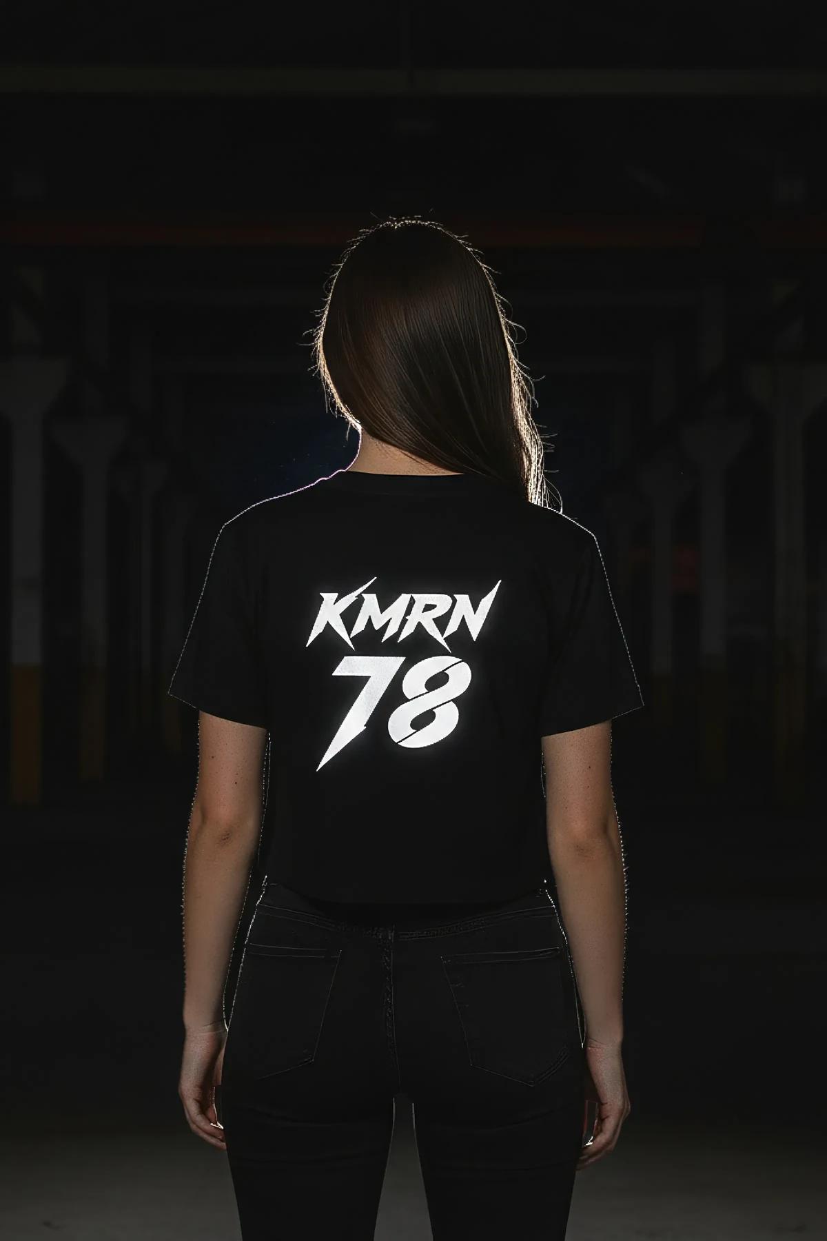 black oversized graphic tee back panel with retroreflective white lettering under direct light