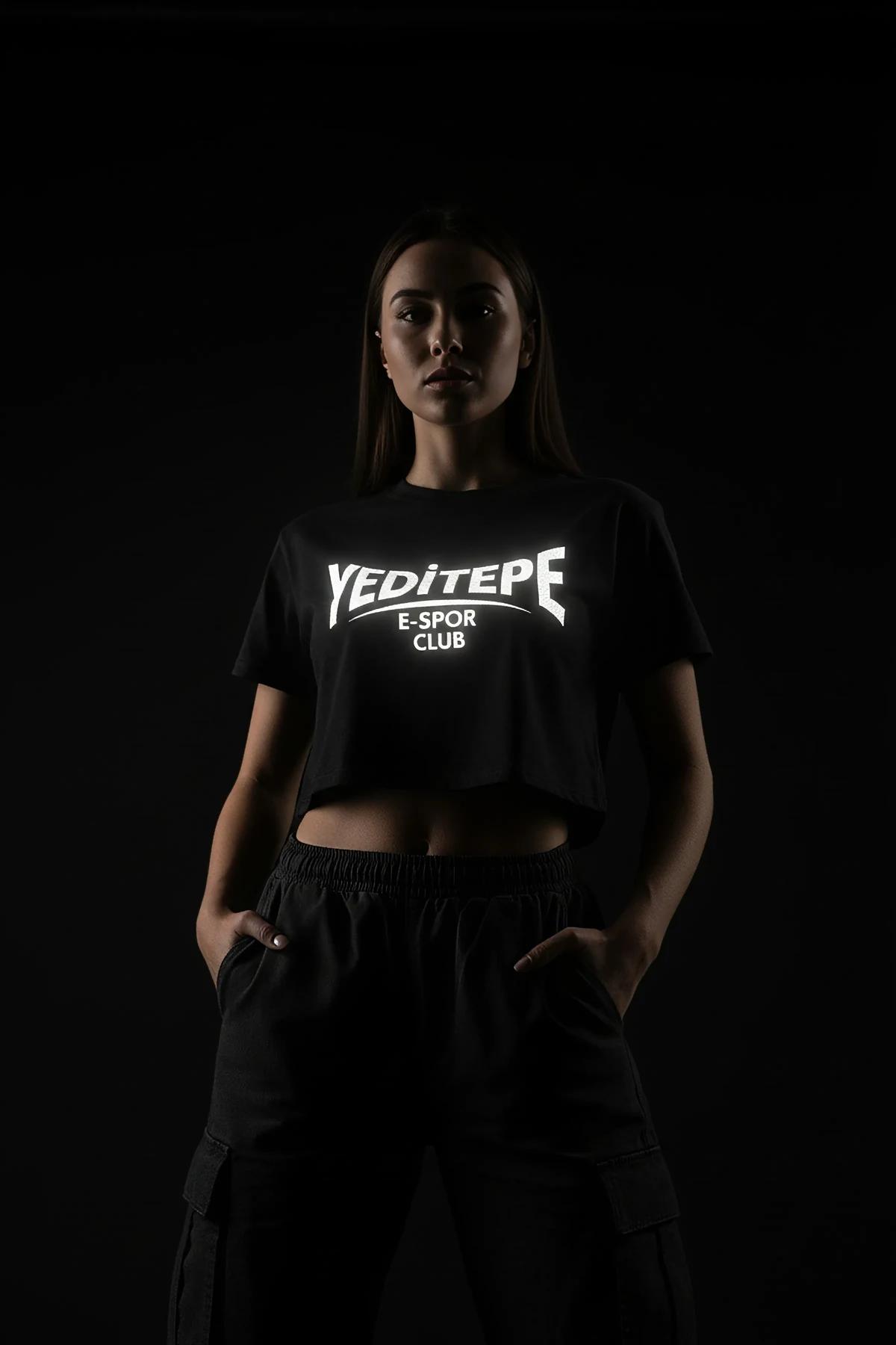 close-up of reflective block-letter chest graphic on black jersey crop top