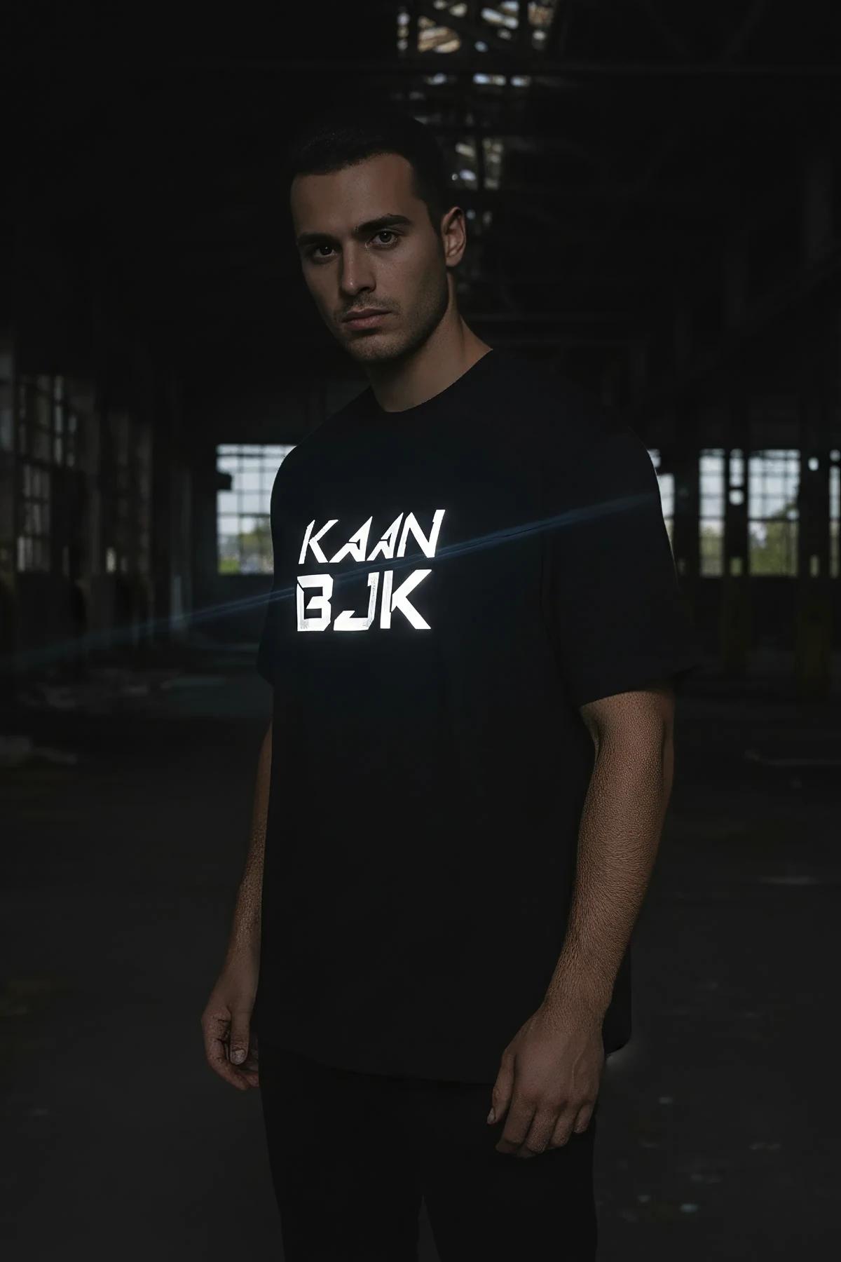 side profile of black drop-shoulder oversized tee showing longline hem length