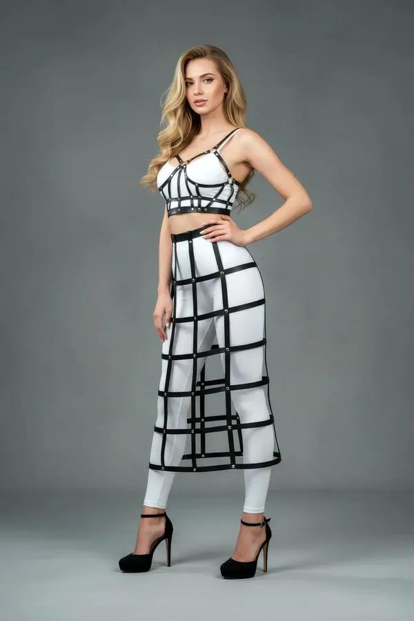 Black faux leather cage midi skirt with horizontal strap tiers and silver stud intersections, side view