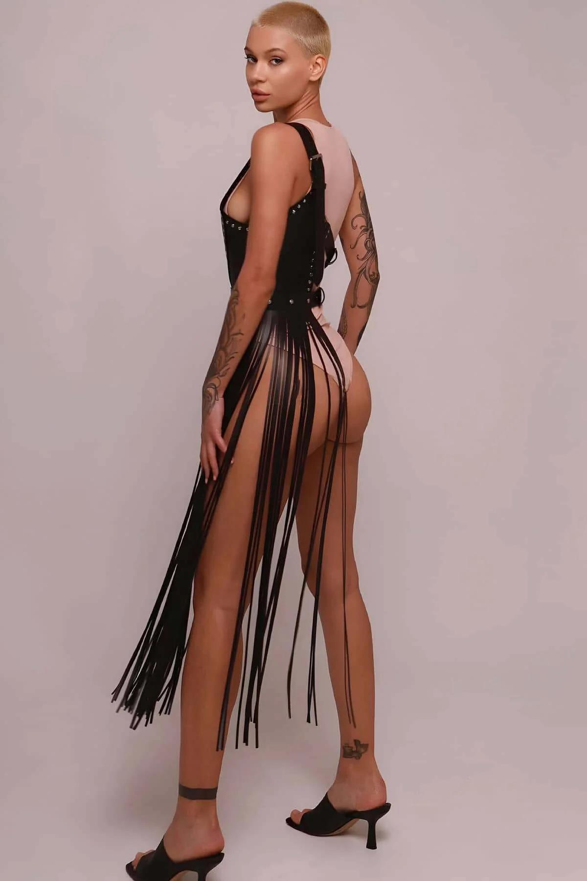 Side view of long black faux leather fringe falling approximately 60-70 cm from hip