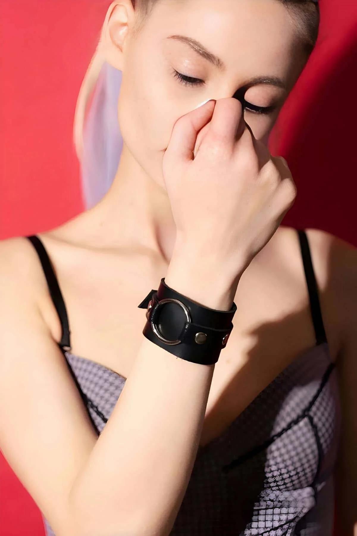 adjustable black faux leather wrist cuff flat lay showing inner smooth surface and snap button