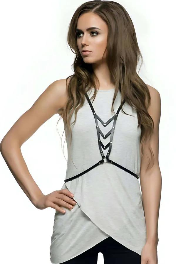 Black faux leather chest harness with stacked chevron wave straps and silver studs worn over white tank top