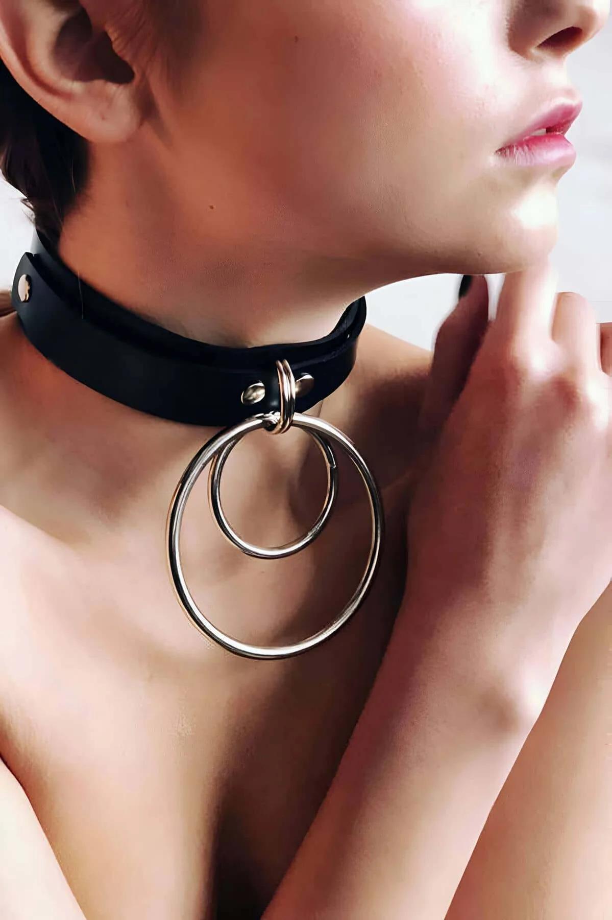 Close-up of interlocking silver O-rings attached to black faux leather choker collar