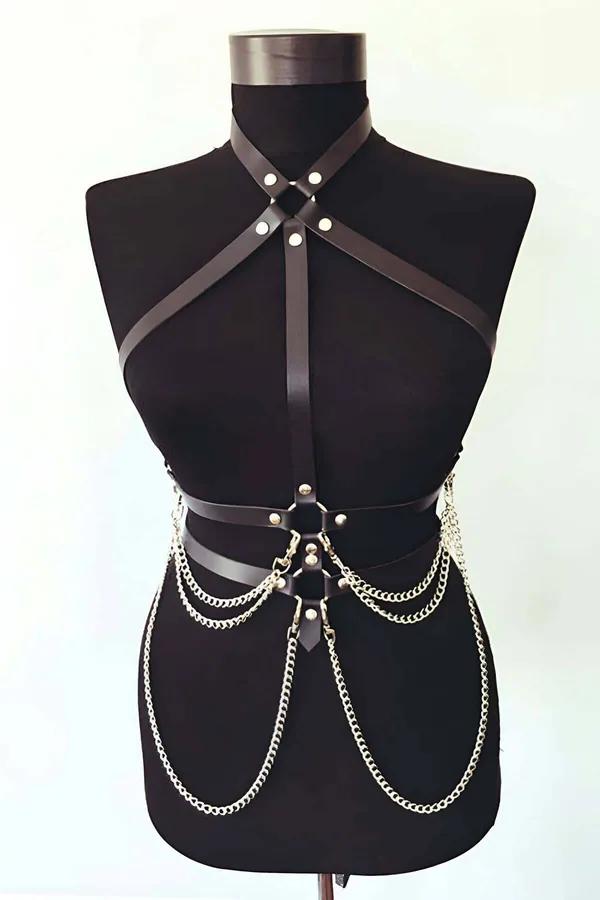 Black faux leather chest harness cross strap and draped gold chain detail on model