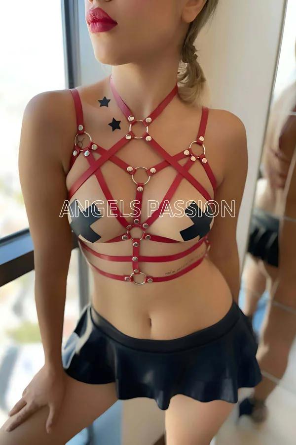 Red faux leather starburst body harness with silver O-rings and dome-head rivets on geometric crossing chest straps