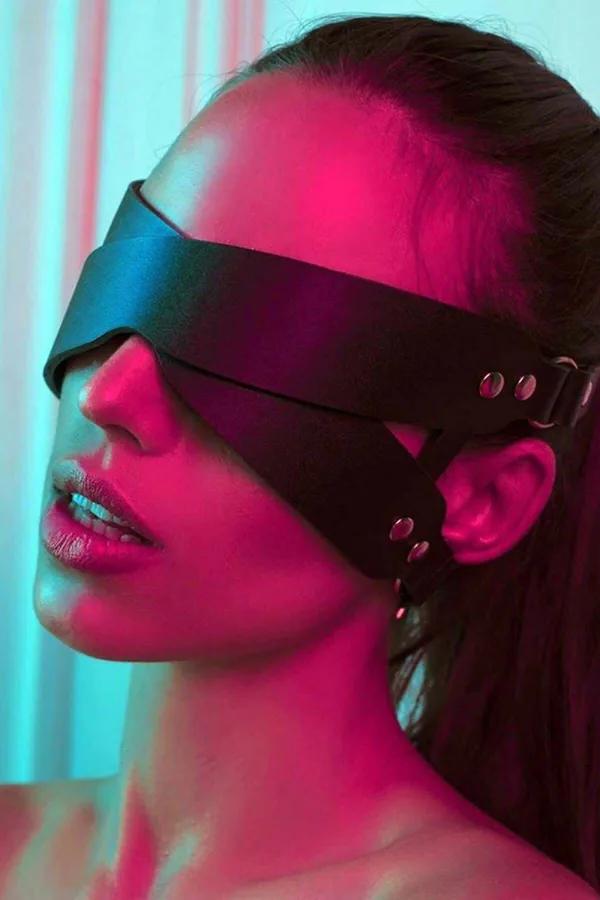 Black faux leather blindfold eye mask with wide panel and silver buckle adjustable strap worn on face