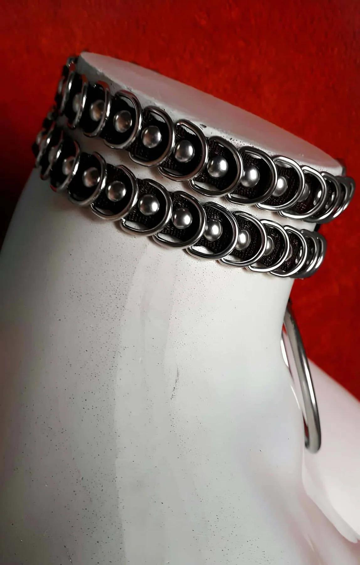 Front view of black ring choker with small connector O-ring and large 6 cm silver pendant ring hanging at center