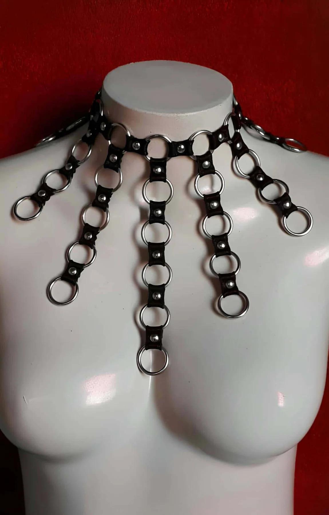 Close-up of star-shaped rivet hardware on black faux leather choker harness shoulder straps