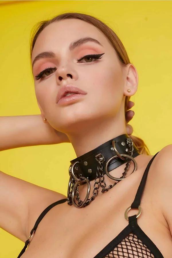 Black wide faux leather choker with gunmetal O-rings and draped chains worn around neck
