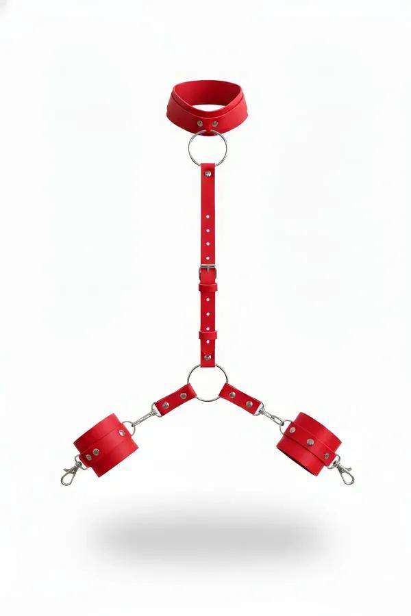 Red faux leather collar and handcuff set with silver O-rings, adjustable strap, and lobster clasp wrist cuffs on white backgr