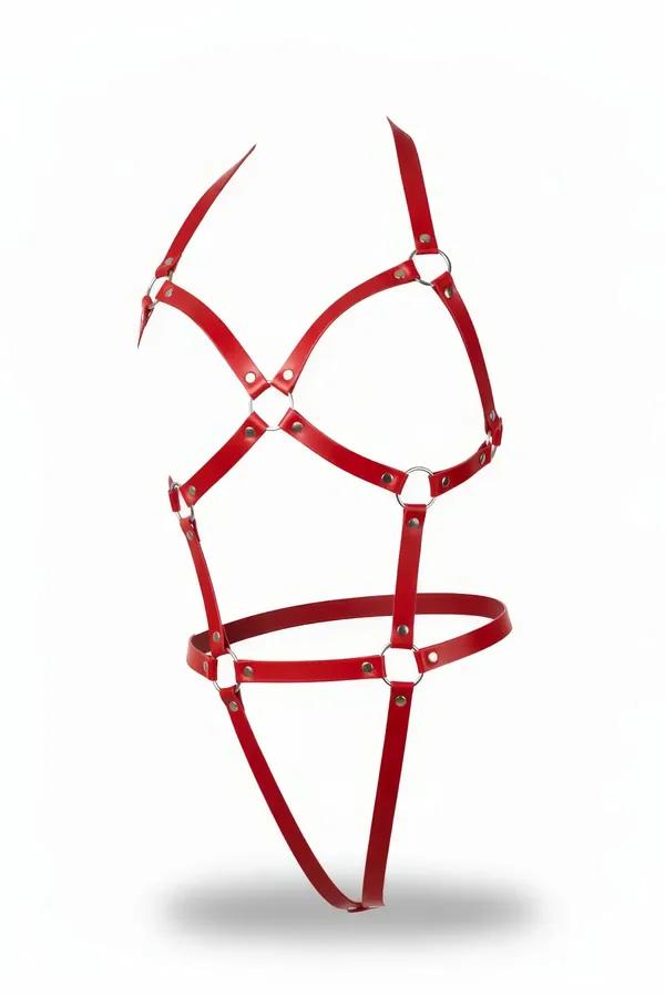 Red faux leather full body harness with silver O-ring connectors and X-pattern chest straps against white background