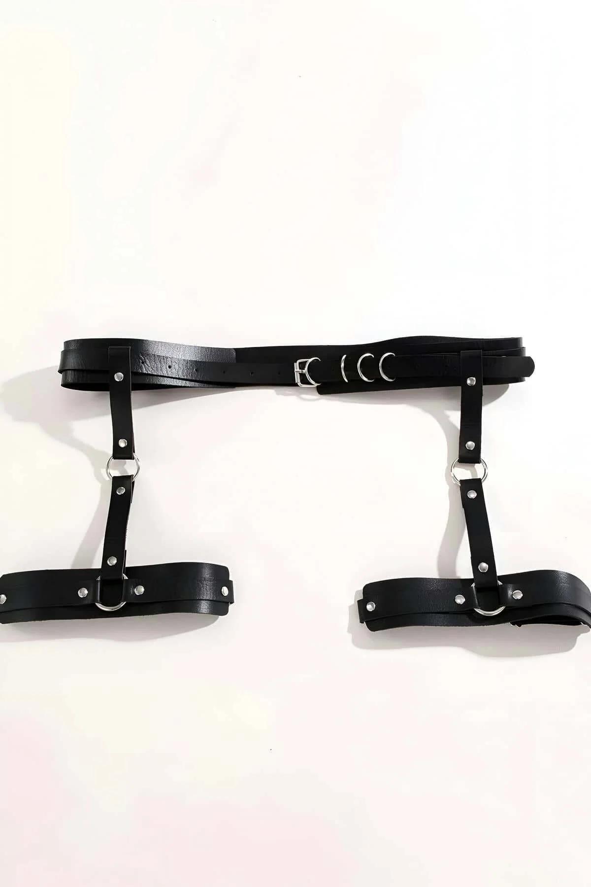 close-up of silver O-ring and dome rivets on black vegan leather harness strap