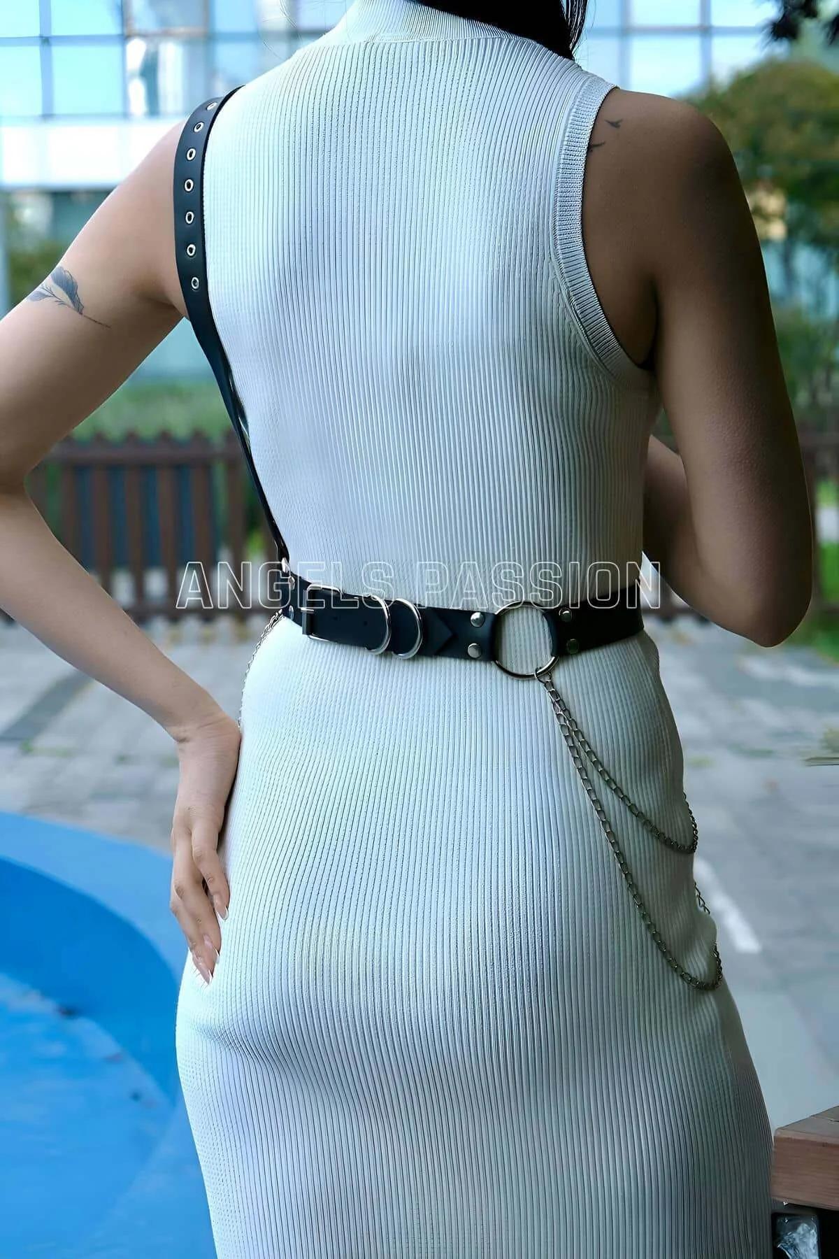 Side view of black asymmetric chest strap crossing diagonally over white ribbed dress