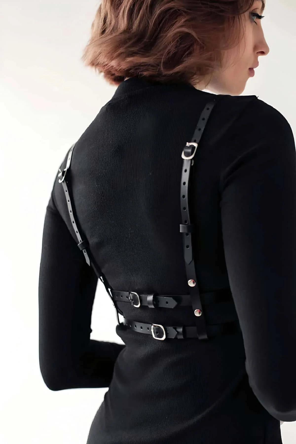 Silver O-ring chest connector on black faux leather shoulder strap harness front view