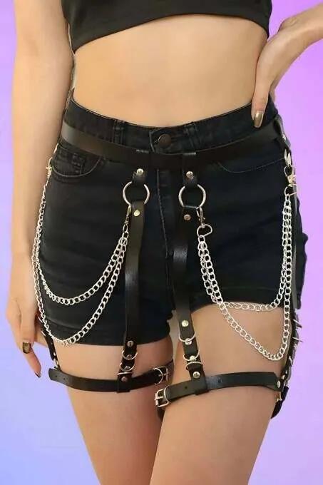black vegan leather chain garter harness, silver O-ring and double row drop chain, worn over denim shorts