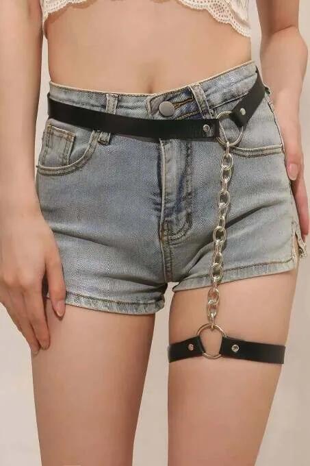 black faux leather waist garter harness with detachable silver link chain and O-ring hardware over denim shorts