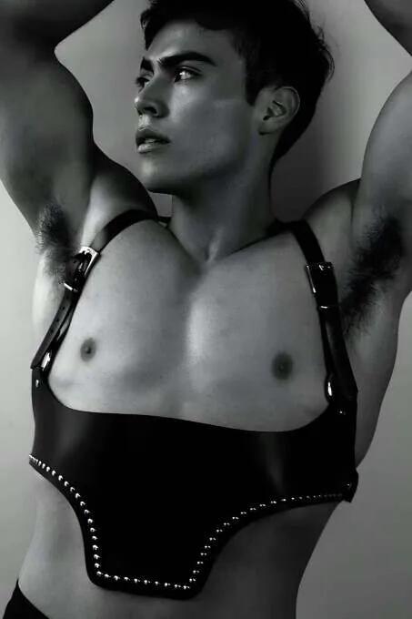Black faux leather underbust harness with silver stud trim along hem and silver buckle adjustable shoulder straps on male mod