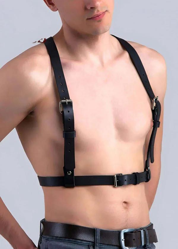 black vegan leather adjustable chest harness with four silver buckle straps worn by male model over bare torso