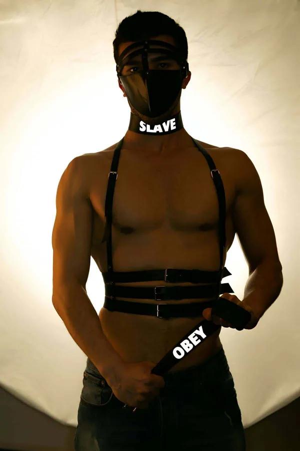 Black reflective chest harness with choker and dual waist strap set, silver roller buckles, worn front view
