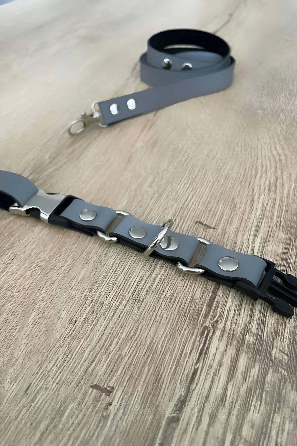 grey vegan leather cat harness set silver steel clasp and matching leash on wooden surface