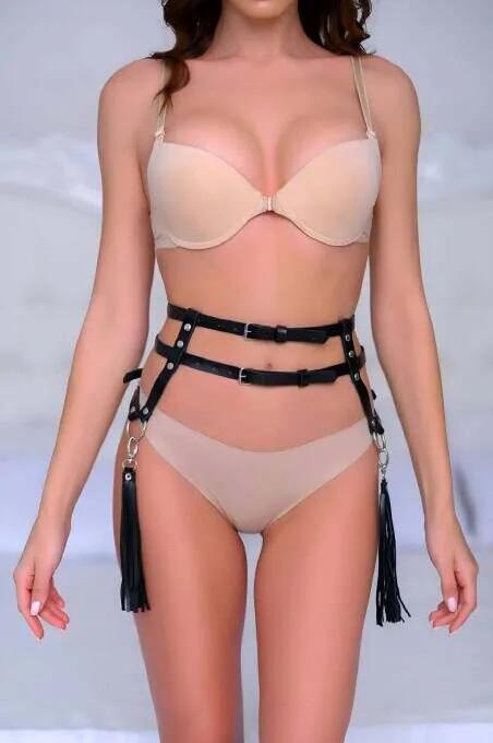 Black faux leather waist harness with double straps, silver buckles, O-rings, and long black tassels at each hip