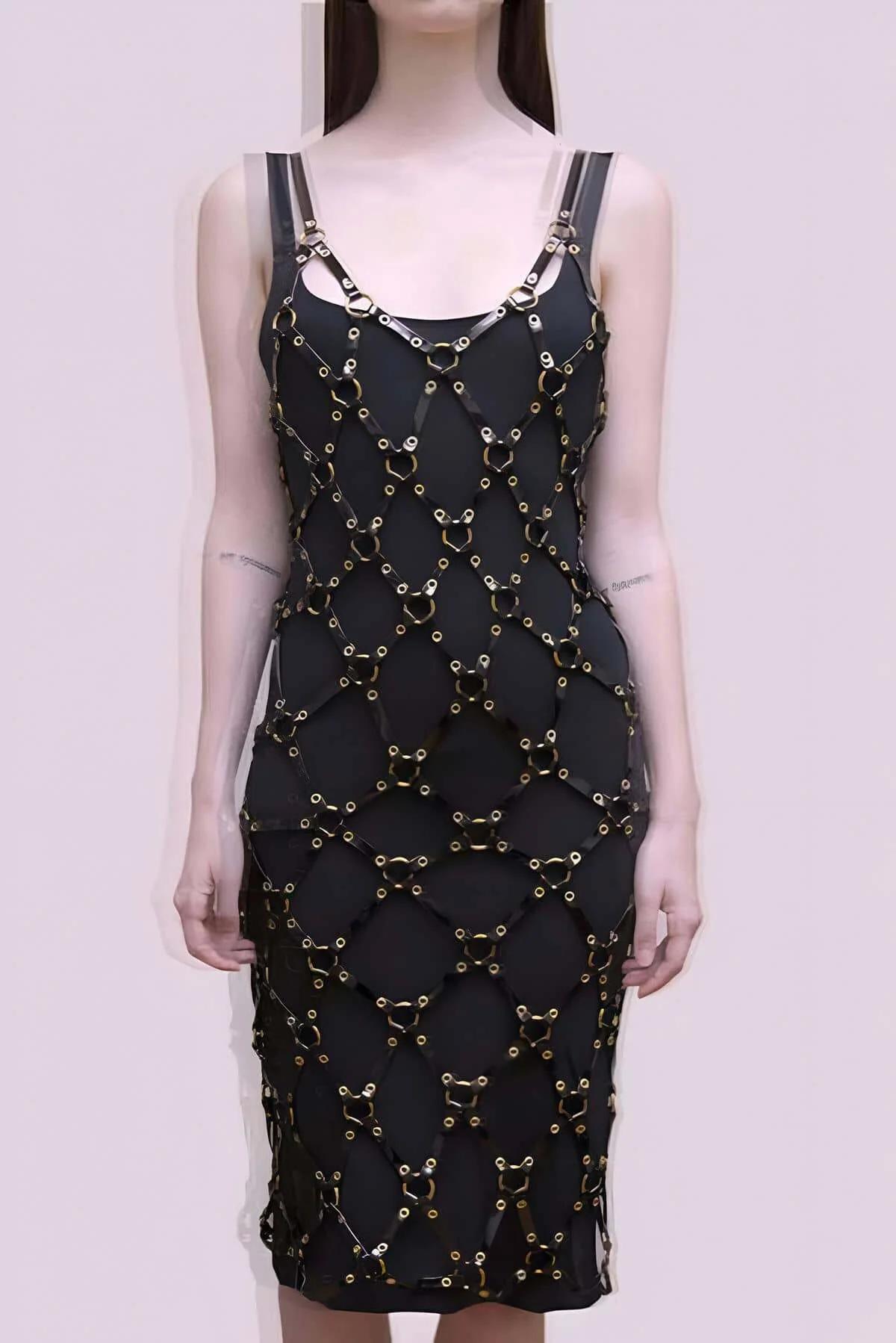 Black faux leather geometric panel overlay harness midi dress with gold O-ring hardware linking panels from neckline to hem