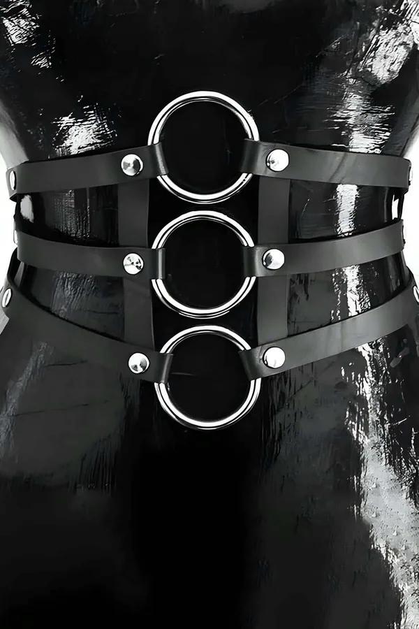 black faux leather waist harness with three stacked silver O-rings and dome rivets on female torso