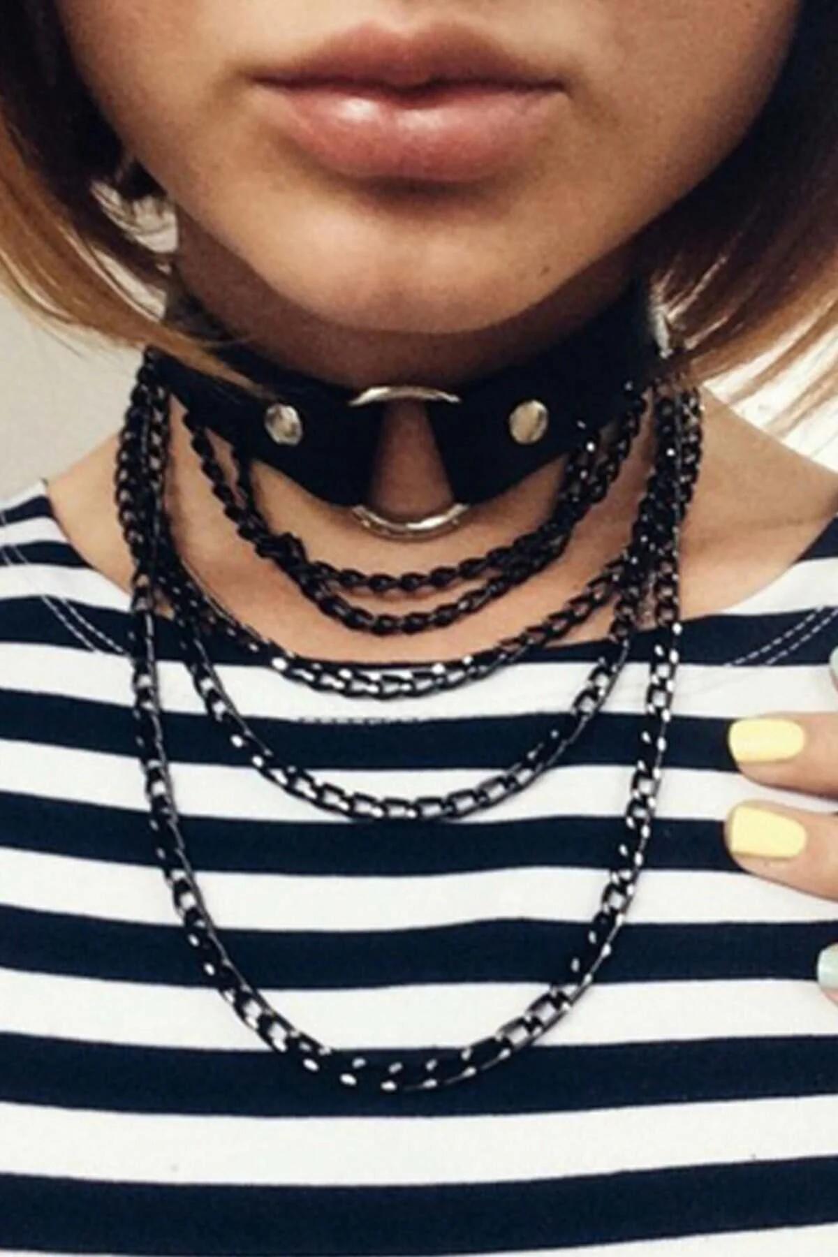 black faux leather layered chain choker with silver O-ring and four cascading black metal chains worn at throat