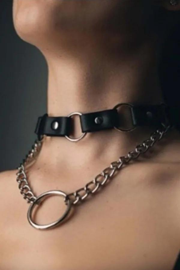 Black faux leather choker with silver curb chain and large O-ring pendant worn at base of throat
