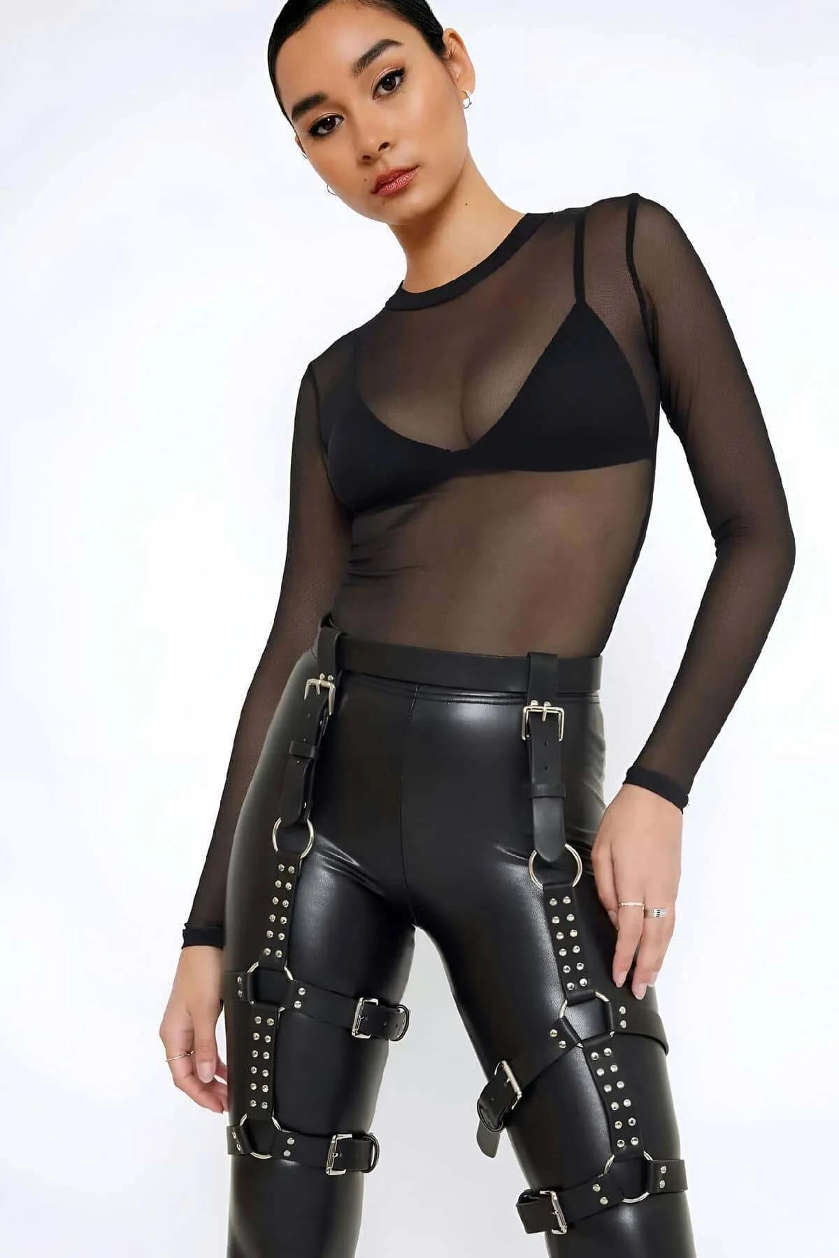 Black faux leather studded thigh harness with silver buckles and O-rings worn over black faux leather trousers