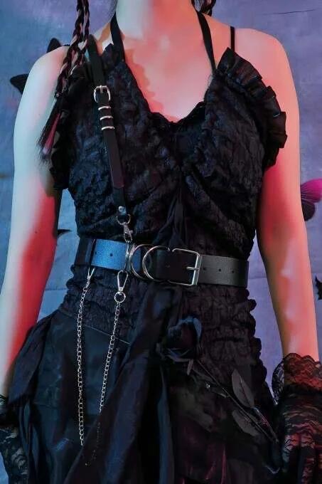 Black faux leather single-shoulder harness with wide waist belt and detachable silver chain drop, worn over dark lace dress